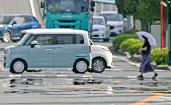 今年初の猛暑日となり空気が揺らいで見え、路面に現れた「逃げ水」＝７日午後３時40分、佐野市高萩町