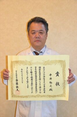 表彰状を手にする平井さん