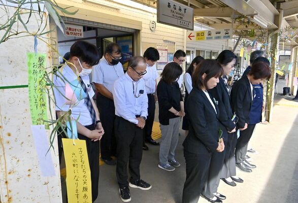 作新学院の児童生徒らの短冊（左）が飾られたのと鉄道穴水駅のホームで黙とうする職員ら＝１日午後４時10分、石川県穴水町大町