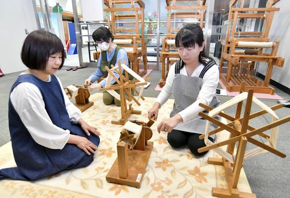 吉沢さん（左）の指導で糸を巻く受講生