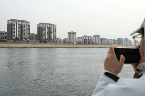 　鴨緑江を挟んで中国の対岸にある北朝鮮の新義州周辺＝３月、中国遼寧省丹東から撮影（共同）