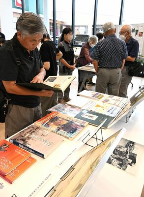 宇都宮空襲に関する本や資料に見入る来場者＝12日午後、宇都宮市一条１丁目
