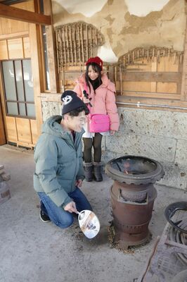 かまどでの炊飯を体験するびーむ先生（奥）と井坂さん＝20日午前、大田原市