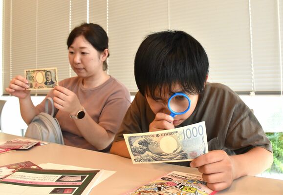 新紙幣を観察する親子