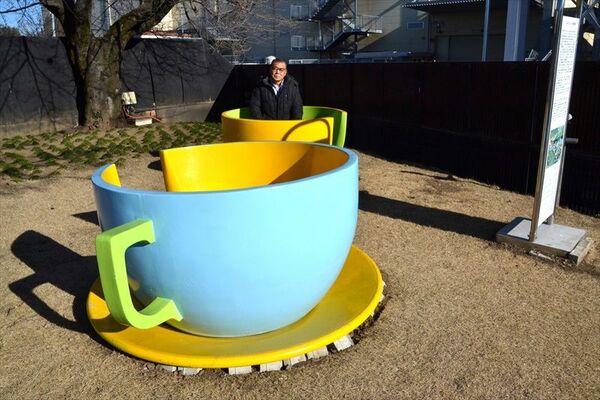 開園当時の「コーヒーカップ」に座る青木さん