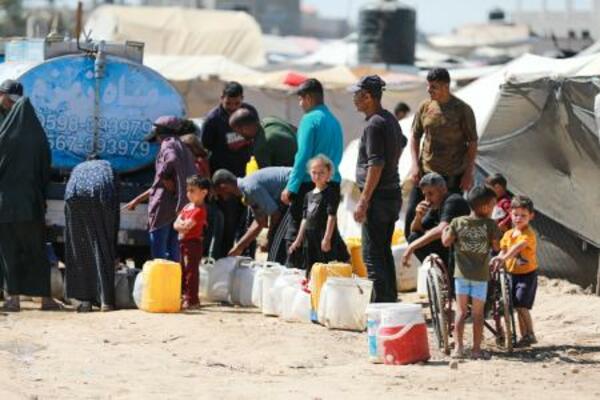 パレスチナ自治区ガザの難民キャンプで、飲料水の供給を並んで待つ人たち=1日(ゲッティ=共同)