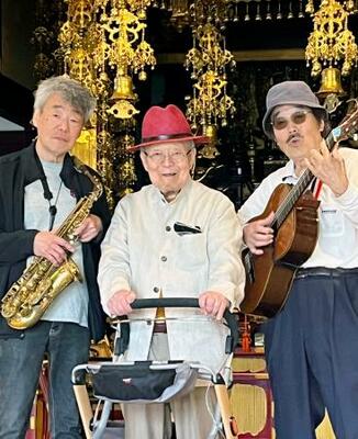 　本行寺本堂でミュージシャンの音楽を聴く住職の加茂行昭さん（中央）＝東京都荒川区