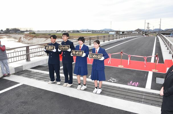 揮毫した両明橋の橋名板を披露する大平南中の生徒ら