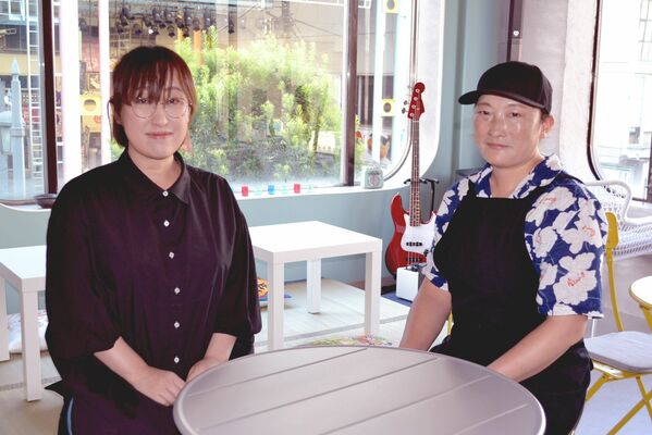 ナマイさん（左）と店長。大きな窓からはオリオン通りや釜川が見える