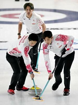 　男子プレーオフ　中国戦の第６エンド、スイープする柳沢（右）と山本。奥は小泉＝ケロウナ（共同）