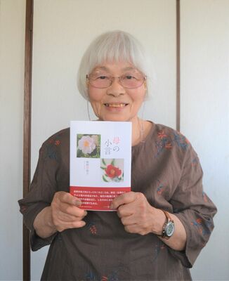 著作を手にする伊藤洋子（ペンネーム秋野沙夜子）さん
