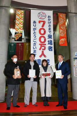 記念品を手に記念撮影する谷島さん夫婦（中央）。右は道の駅きつれがわ社長の花塚市長