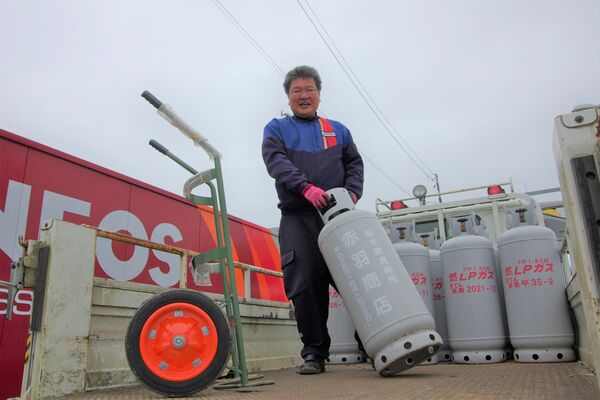 ガスボンベを移動させる吉川さん