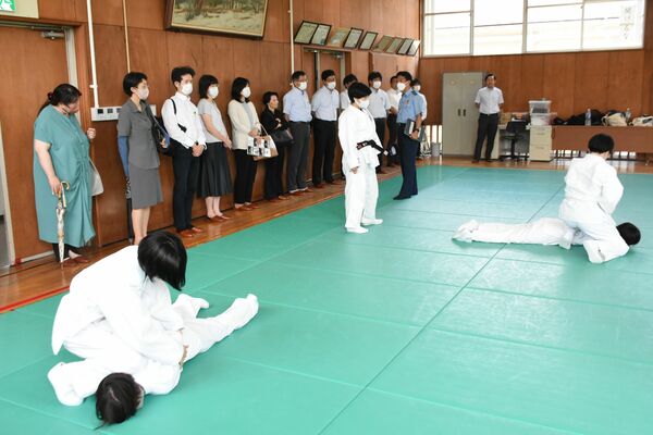逮捕術の授業を見学する県内高校の就職担当者ら＝11日午後、県警察学校