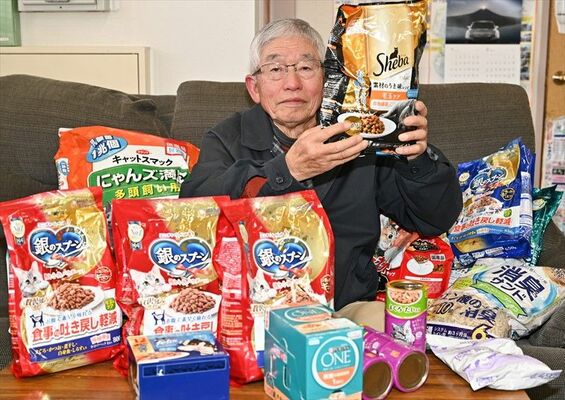 寄せられたペットフードや飼育グッズを掲げる松田会長