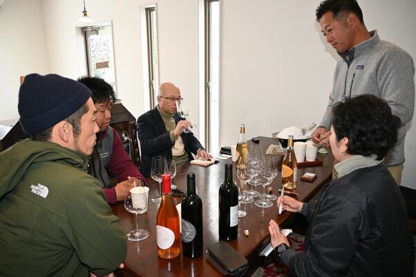 「ヒノエワイン」を試飲する視察の一行と吉村夫妻（右）＝２月８日、宇都宮市新里町