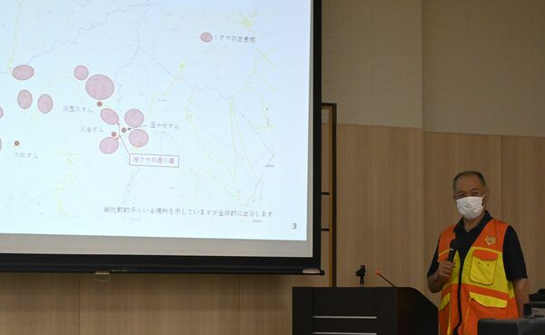 スライドを使いながらクマの生態を説明する阿部地区長＝７月１日午後、日光市鬼怒川温泉大原