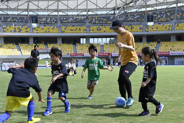 鮫島さんと一緒にボールを追う子どもたち