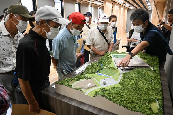 ジオラマを見ながら施設の説明を受ける住民＝10日午後、那珂川町和見