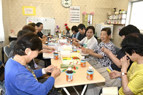 折り紙をしながら会話に花を咲かせる「カトレアの会」のメンバー