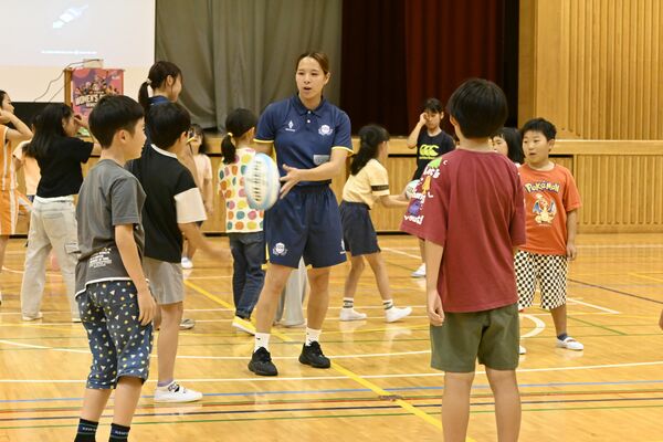 内海選手(中央)とパス交換の練習をする児童たち