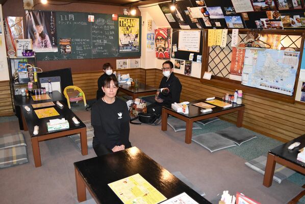 北海道の地図や写真などが所狭しと貼られた店内。手前が沢村さん