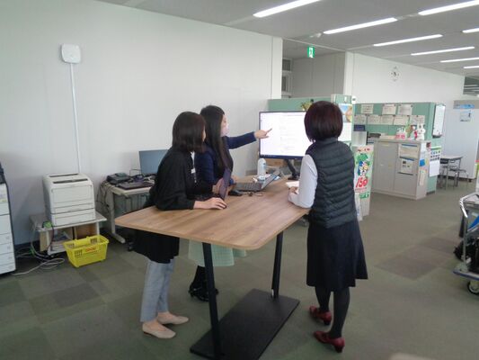 打ち合わせをする県職員。時間短縮のため、スタンディングテーブルやモニターの活用が進んでいる＝４月上旬、県庁