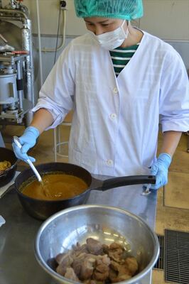 煮込んだイノシシ肉とルーを混ぜる試作中の須藤さん