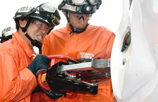 実車を使い、真剣な表情で救助訓練に当たる隊員たち