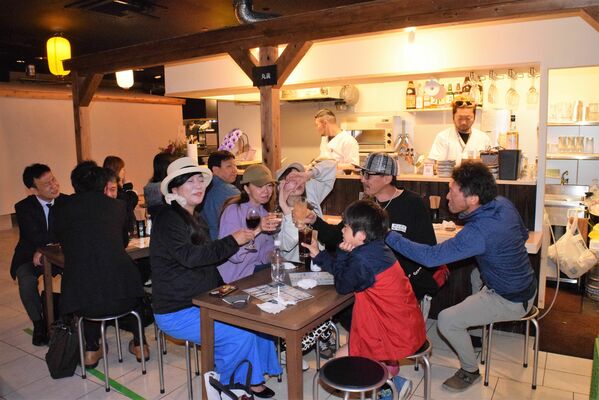 通路のテーブルで飲食を楽しめる屋内型屋台村「夜市横丁」＝８日夜、宇都宮市