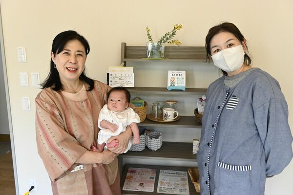 産後ケア施設を利用していた生後１カ月の乳児を抱っこする小嶋さん（左）とことり助産院のスタッフ