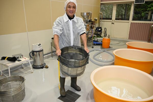 極寒の中、素手で７キログラムの掛け米を洗米する筆者＝１月７日、鹿沼市上粕尾