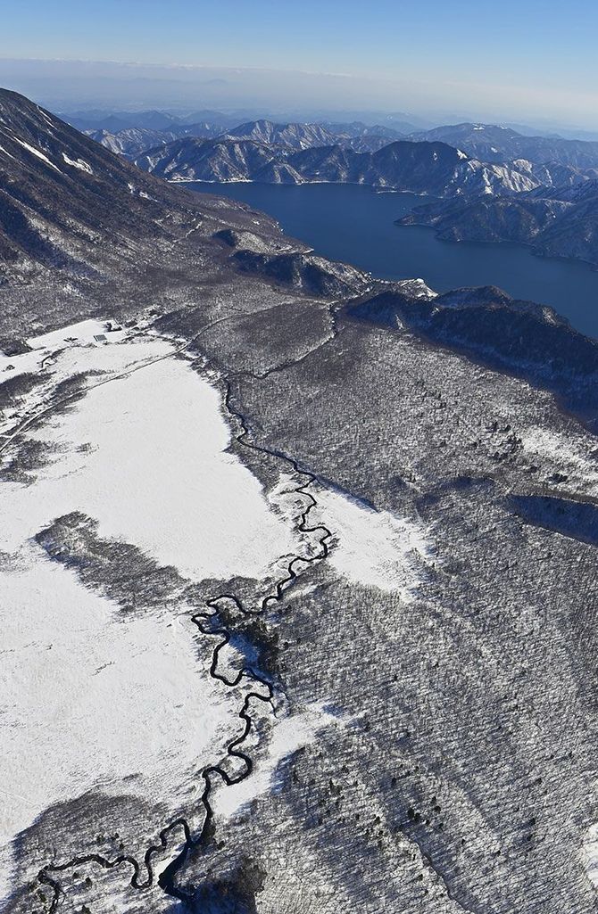 冬化粧した戦場ケ原を蛇行する湯川が、中禅寺湖へと向かう（ヘリから撮影）
