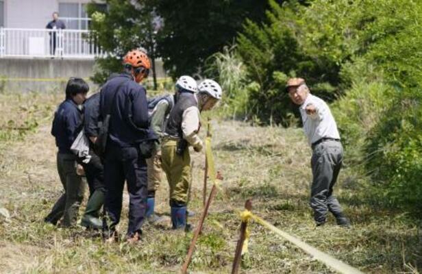 　北海道福島町で、ヒグマに襲われた男性が倒れていた現場付近を調べる町役場職員ら＝７月