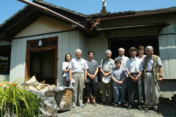 大嶹商舎の事務所とみられる建物（後方）の解体に当たって、駆け付けた子孫ら関係者＝２０１４年７月、宇都宮市石井町