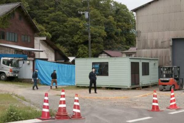 　男性の遺体が土の中に埋められているのが見つかった現場周辺を警戒する広島県警の捜査員ら＝２９日午後６時２６分、広島県三原市