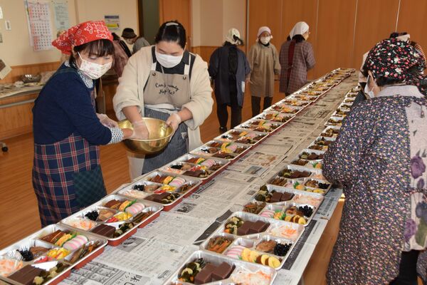 おせち料理を盛り付ける会員
