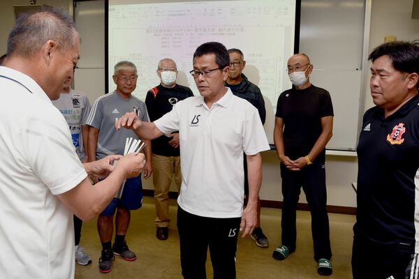 選手宣誓のくじを引く各地区の代表者たち