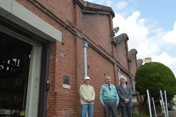 トチセンの赤レンガ捺染工場と論文を執筆した（左から）福島さん、秋草社長、北村さん