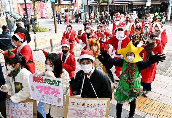 サンタ姿で街を練り歩く参加者ら＝18日午前11時35分、宇都宮市江野町