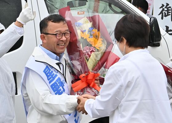無投票で４選を果たし、花束を受け取る星野光利氏＝18日午後５時35分、上三川町しらさぎ１丁目