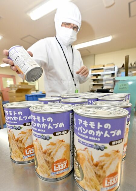 ラベルを貼って並べられる缶詰パン＝28日午前10時20分、那須塩原市東小屋（超広角レンズ使用）