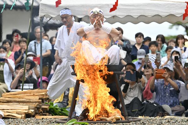 熱した釜の湯に入り経を唱える長浜住職＝28日午前11時35分、那須塩原市沼野田和