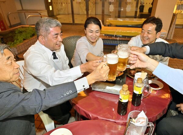 ビアガーデンで乾杯する来店客たち