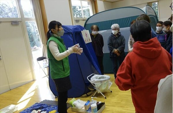 防災セミナーで簡易トイレの使い方を説明する中川さん（左）