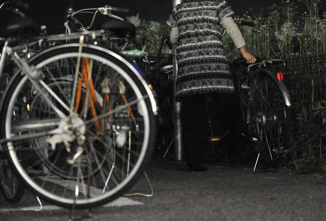 自転車で帰宅する山下さん。生活保護を受けているため、車は持てない=3日夜