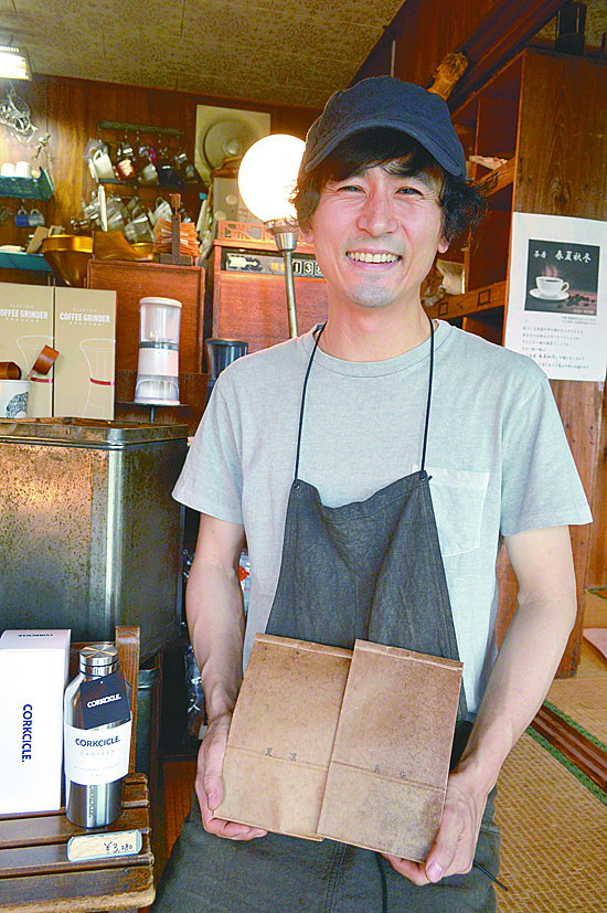 蝋引きの袋は3サイズ。繰り返し使えるのもうれしい。店主の秋元さん。今月から、店の一角でリサイクルショップもオープン予定
