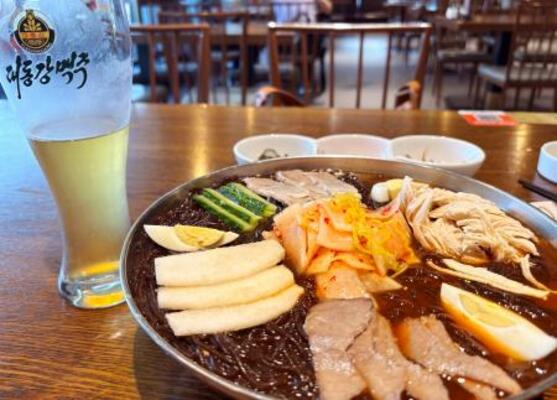 中国にある北朝鮮レストランで提供された北朝鮮製ビールと冷麺=7月(共同)