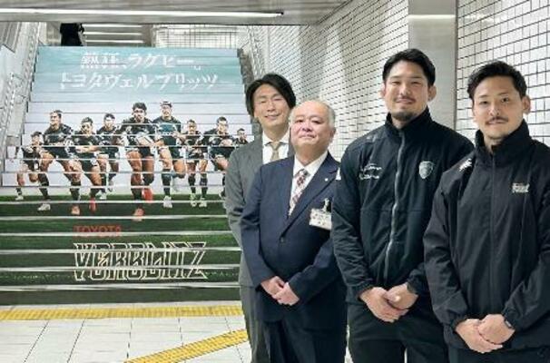 　瑞穂運動場西駅の装飾された階段の前で、写真に納まるラグビー・リーグワン１部トヨタの姫野主将（右から２人目）＝２９日、名古屋市