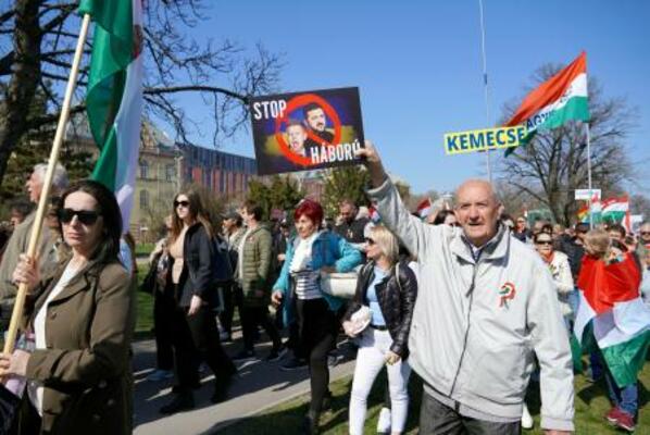 プラカードを掲げるハンガリーの与党「フィデス・ハンガリー市民連盟」の支持者ら=15日、ブダペスト(共同)